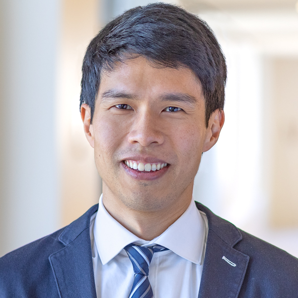 Headshot of David Zhao in a suit with blue, striped tie.